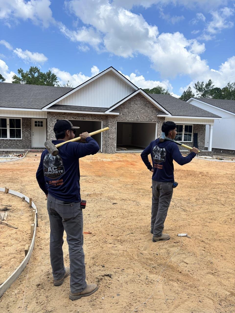 Two AC crew members in branded hoodies at a new home